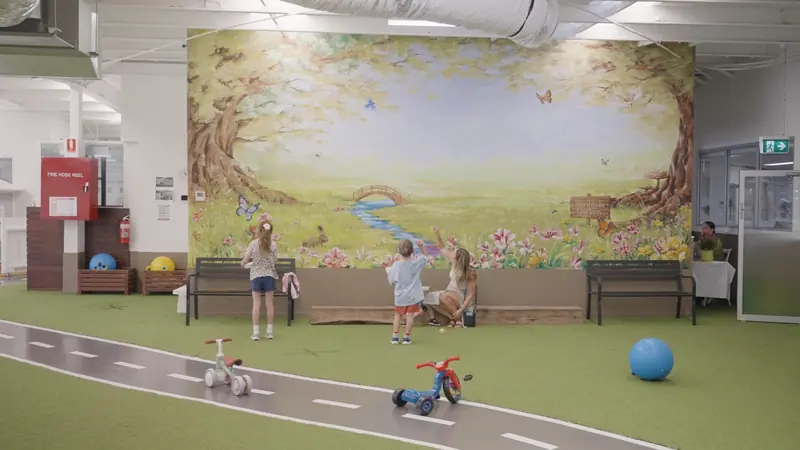 A painted storybook mural beside the bike track