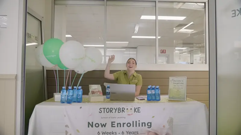 An educator welcoming families at the Storybrooke enrolment table on opening day