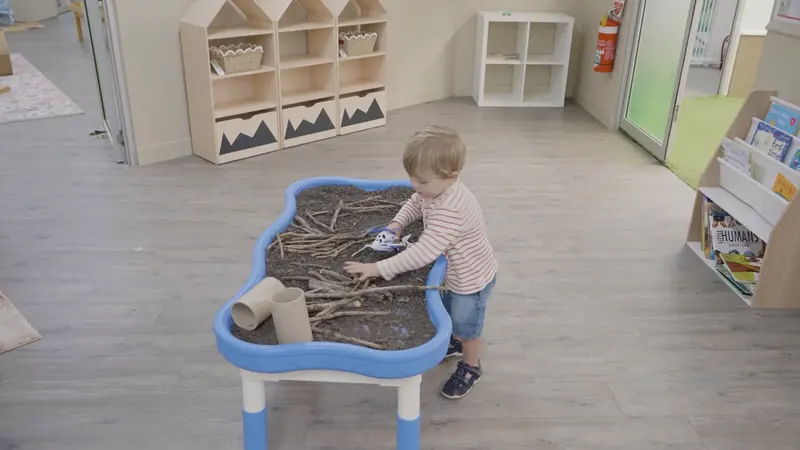 A toddler exploring a sensory table